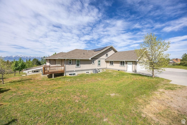 304 N 1000 E, Hyde Park, UT 84318 - rear view of house featuring a yard, driveway, stucco siding, cooling unit, and roof mounted solar panels