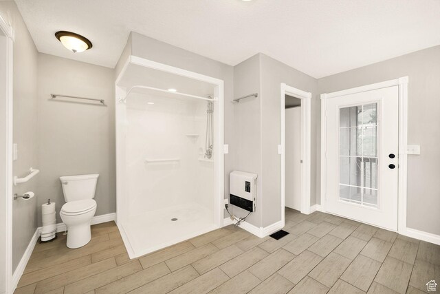 304 N 1000 E, Hyde Park, UT 84318 - bathroom with heating unit, wood finish floors, baseboards, a shower stall, and toilet