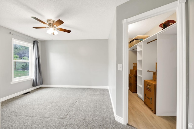 304 N 1000 E, Hyde Park, UT 84318 - unfurnished bedroom with baseboards, light carpet, a textured ceiling, and ceiling fan