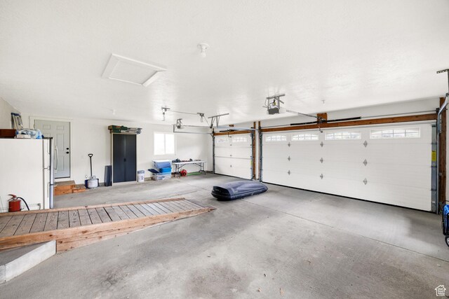 304 N 1000 E, Hyde Park, UT 84318 - garage featuring freestanding refrigerator and a garage door opener