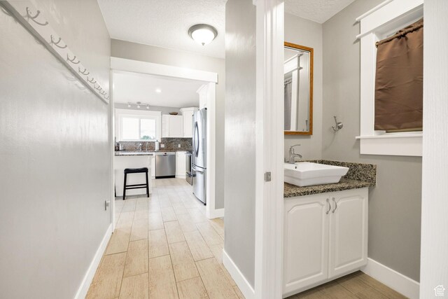 304 N 1000 E, Hyde Park, UT 84318 - hallway featuring a sink, light wood finished floors, and baseboards