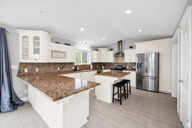 304 N 1000 E, Hyde Park, UT 84318 - kitchen with appliances with stainless steel finishes, wall chimney range hood, a kitchen breakfast bar, vaulted ceiling, and a sink