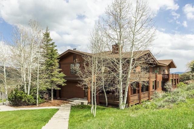 8430 Gambel Dr Unit Q23, Park City, UT 84098 - view of front facade with a front lawn, a chimney, and a wooden deck