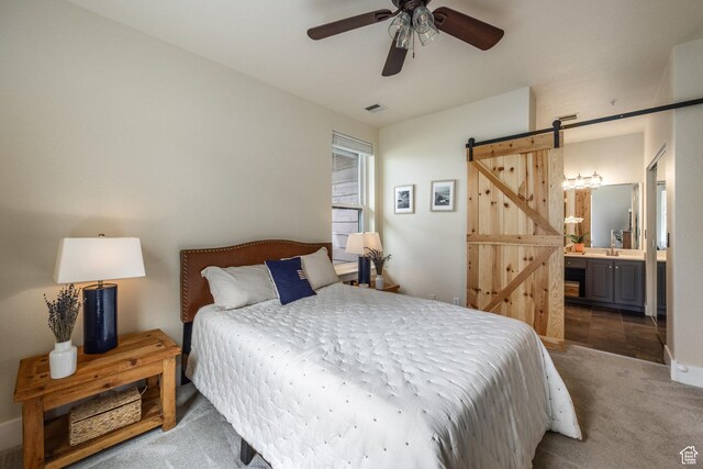 8430 Gambel Dr Unit Q23, Park City, UT 84098 - carpeted bedroom featuring a barn door, connected bathroom, and a ceiling fan