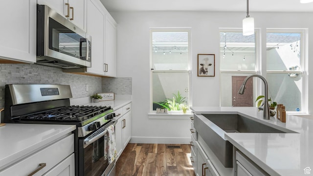 5241 W S Jordan Pkwy, South Jordan, UT 84009 - kitchen with stainless steel appliances, tasteful backsplash, dark wood-type flooring, a sink, and light countertops
