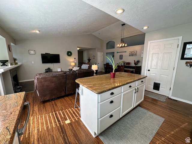 8675 S Pebblecreek Rd, West Jordan, UT 84081 - kitchen featuring vaulted ceiling, white cabinetry, dark wood-type flooring, baseboards, and a textured ceiling