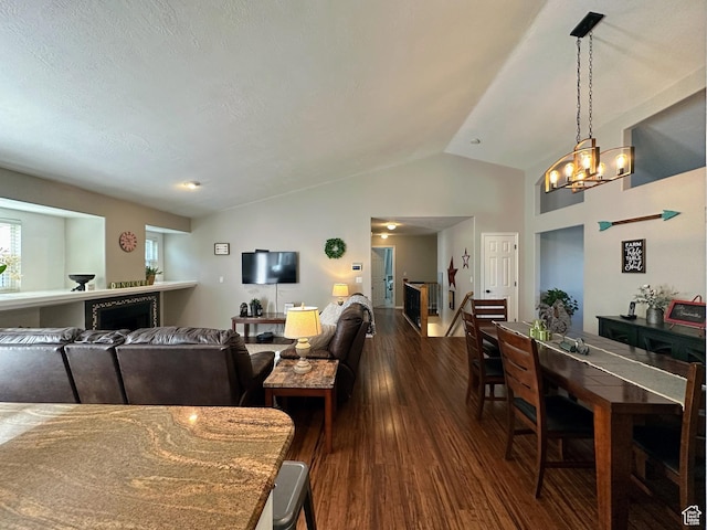 8675 S Pebblecreek Rd, West Jordan, UT 84081 - dining area featuring dark wood-style flooring, lofted ceiling, a chandelier, and a fireplace