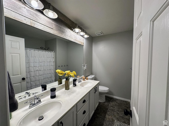 8675 S Pebblecreek Rd, West Jordan, UT 84081 - bathroom featuring toilet, double vanity, baseboards, and stone finish floors