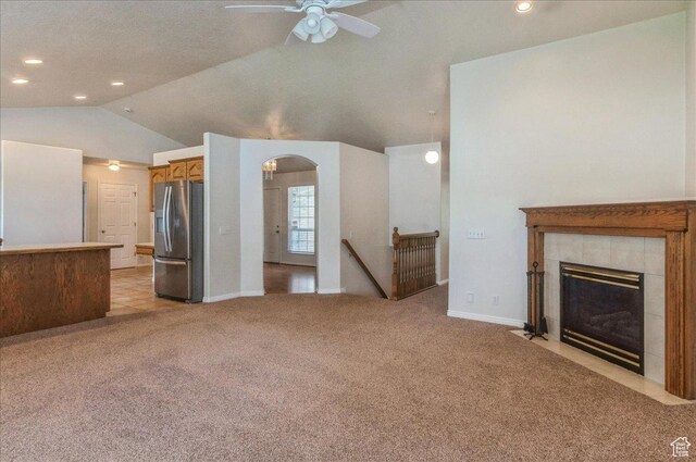 432 S 755 E, Layton, UT 84041 - unfurnished living room featuring light colored carpet, a ceiling fan, vaulted ceiling, arched walkways, and a fireplace