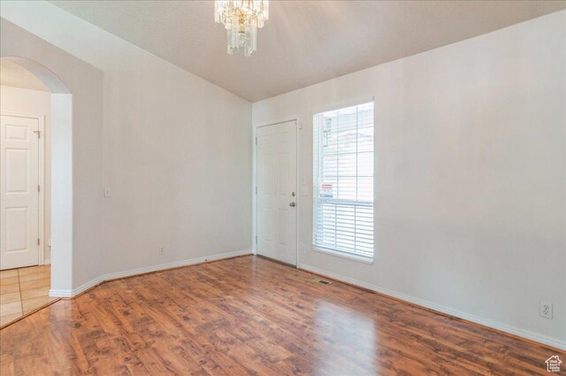 432 S 755 E, Layton, UT 84041 - unfurnished room with arched walkways, wood finished floors, baseboards, and a chandelier