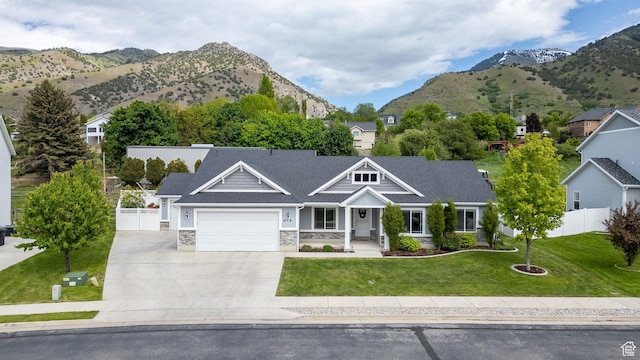 818 S 560 E, Providence, UT 84332 - view of front of house with an attached garage, driveway, a mountain view, and stone siding