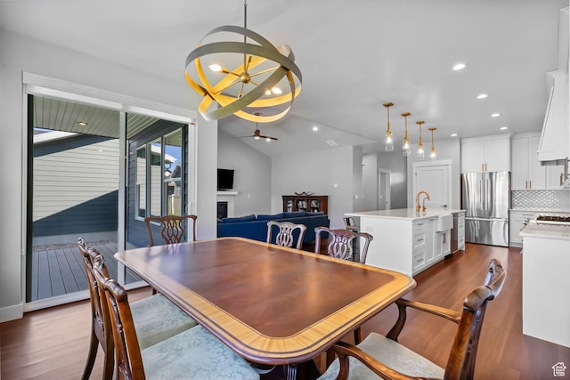 3205 W Oxford Loop, Mountain Green, UT 84050 - dining space featuring a ceiling fan, a fireplace, dark wood-style floors, recessed lighting, and a chandelier