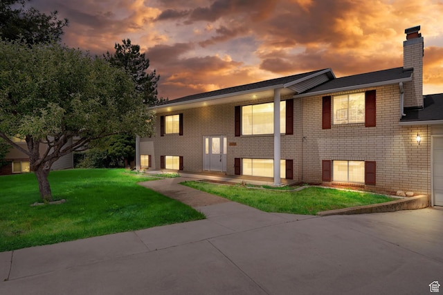 1173 N 350 W, Centerville, UT 84014 - bi-level home with a chimney, brick siding, a yard, and a garage