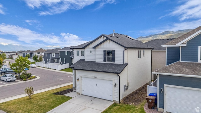 7185 N Hidden Steppe Bnd, Eagle Mountain, UT 84005 - view of side of home featuring roof with shingles, a garage, driveway, a residential view, and a mountain view
