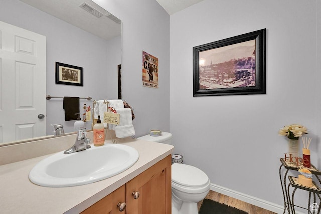 1427 S Blossom Ln, Ogden, UT 84404 - half bath with vanity, toilet, wood finished floors, and baseboards