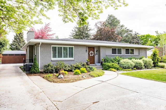 2262 E 1700 S, Salt Lake City, UT 84108 - view of front of home featuring a chimney, brick siding, an outbuilding, central air condition unit, and driveway