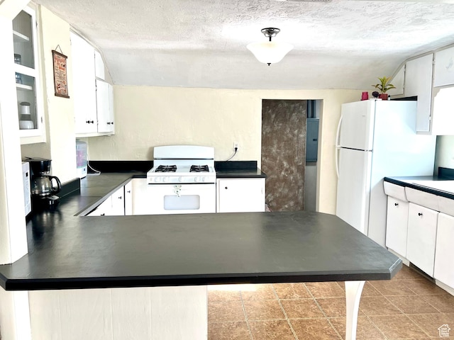 145 N 200 W, Roosevelt, UT 84066 - kitchen with white appliances, dark countertops, a peninsula, white cabinetry, and a textured ceiling