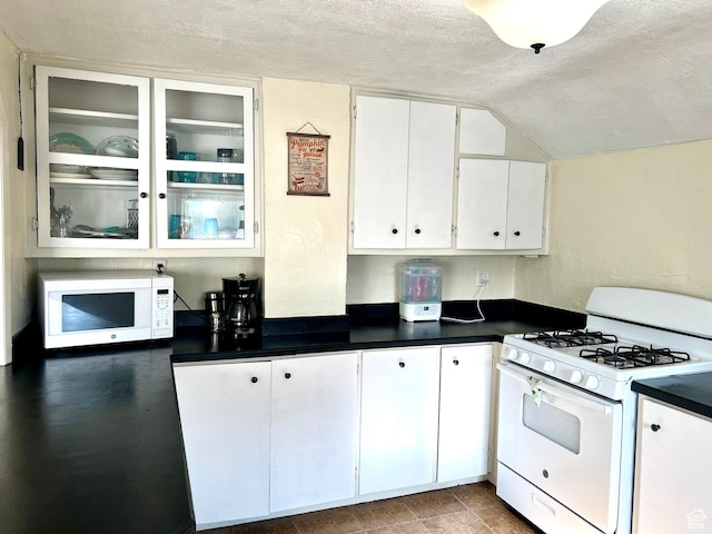 145 N 200 W, Roosevelt, UT 84066 - kitchen featuring white appliances, a textured ceiling, white cabinets, dark countertops, and vaulted ceiling