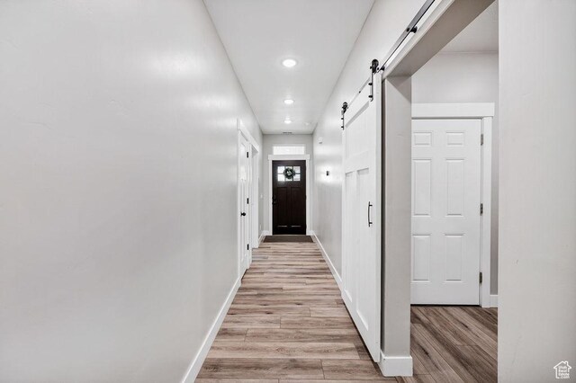 670 N Lake Sight Dr, Garden City, UT 84028 - hall with light wood-style floors, a barn door, recessed lighting, and baseboards