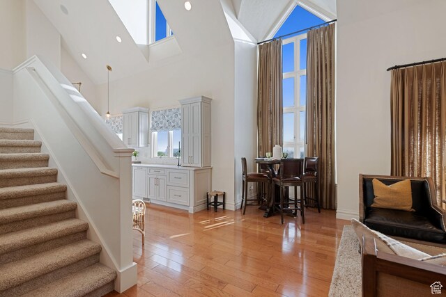 281 N Almond St W, Salt Lake City, UT 84103 - foyer entrance with high vaulted ceiling, stairs, light wood-type flooring, a skylight, and baseboards