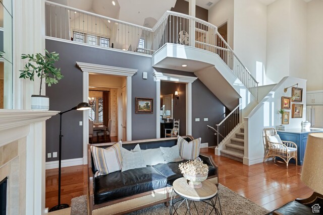 281 N Almond St W, Salt Lake City, UT 84103 - living room with wood finished floors, stairway, a towering ceiling, baseboards, and a high end fireplace