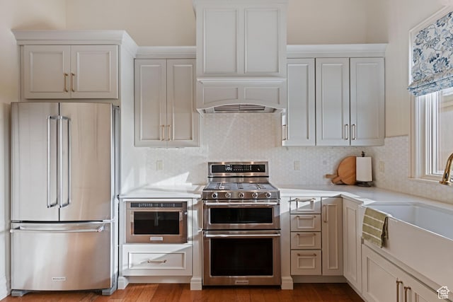 281 N Almond St W, Salt Lake City, UT 84103 - kitchen featuring appliances with stainless steel finishes, light countertops, a sink, tasteful backsplash, and wood finished floors