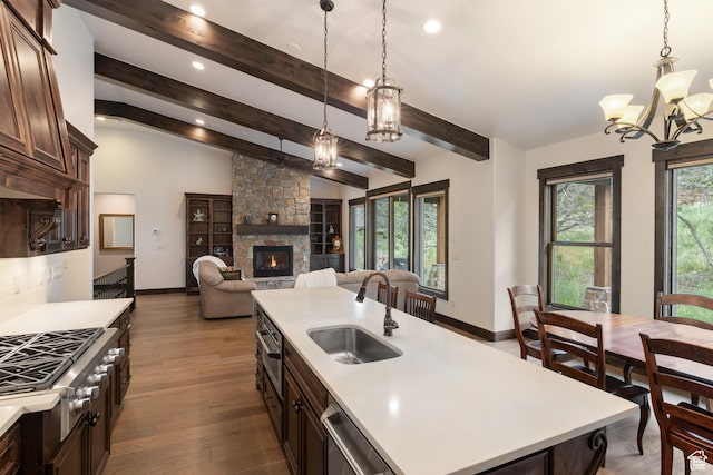 1765 E Kings Peak Cir Unit Cp-21, Heber City, UT 84032 - kitchen featuring a sink, a chandelier, light countertops, a fireplace, and dark brown cabinetry