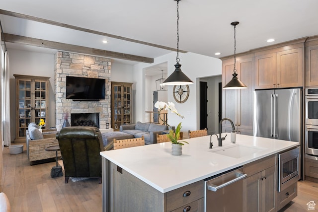 13200 N Alexis Dr, Heber City, UT 84032 - kitchen featuring a sink, stainless steel appliances, open floor plan, a kitchen island with sink, and light wood-style floors
