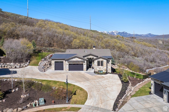 13200 N Alexis Dr, Heber City, UT 84032 - view of front of property with driveway, stone siding, a garage, a mountain view, and a chimney