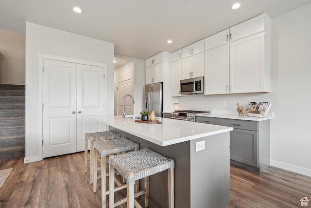 5991 Westridge Rd, Heber City, UT 84032 - kitchen with stainless steel appliances, wood finished floors, baseboards, a center island with sink, and recessed lighting