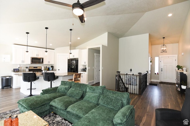 581 W 2030 N Unit 19A, Tooele, UT 84074 - living area with dark wood finished floors, vaulted ceiling, a ceiling fan, a chandelier, and baseboards