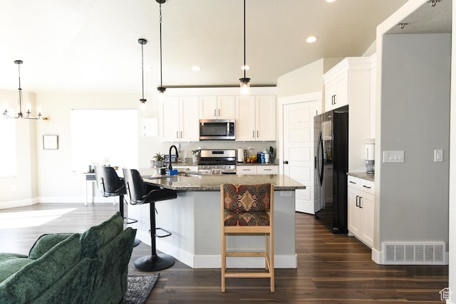 581 W 2030 N Unit 19A, Tooele, UT 84074 - kitchen with stainless steel appliances, a sink, dark wood-style flooring, white cabinetry, and a breakfast bar