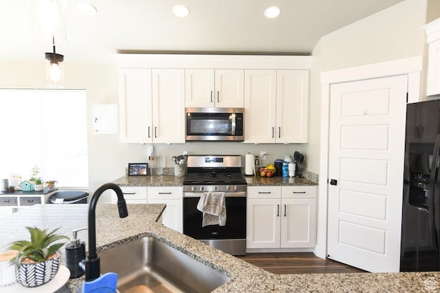 581 W 2030 N Unit 19A, Tooele, UT 84074 - kitchen featuring appliances with stainless steel finishes, a sink, white cabinets, dark wood-style flooring, and light stone counters