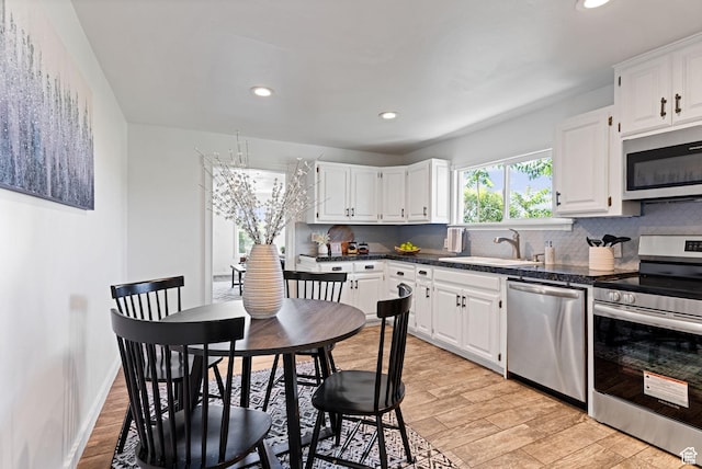 333 S 100 W, Payson, UT 84651 - kitchen with stainless steel appliances, a sink, backsplash, dark countertops, and white cabinets