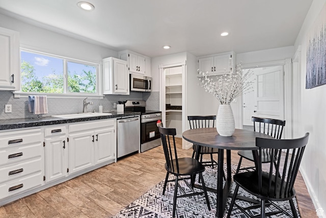 333 S 100 W, Payson, UT 84651 - kitchen with stainless steel appliances, a sink, dark countertops, white cabinetry, and backsplash
