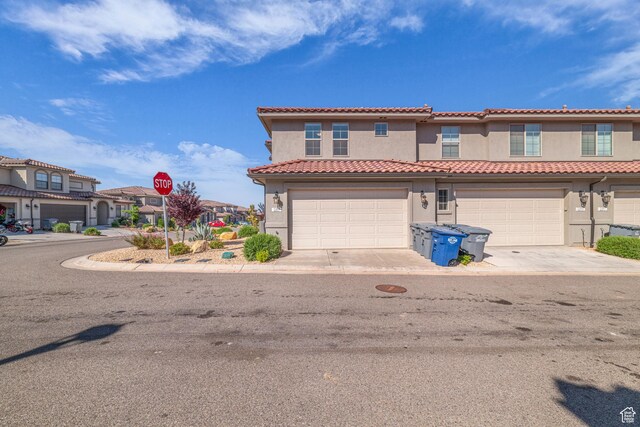 1189 N Bello Aly, Washington, UT 84780 - mediterranean / spanish-style house featuring stucco siding, a tile roof, a garage, a residential view, and driveway