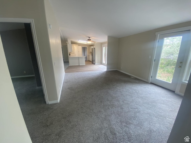 43 E 300 N, Duchesne, UT 84021 - unfurnished living room featuring light carpet, baseboards, and a ceiling fan