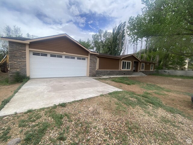 43 E 300 N, Duchesne, UT 84021 - view of front facade featuring concrete driveway, stone siding, and an attached garage