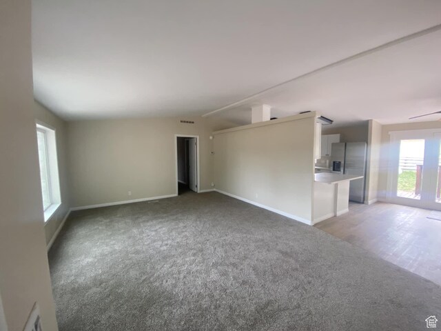 43 E 300 N, Duchesne, UT 84021 - unfurnished living room featuring light colored carpet, lofted ceiling, and baseboards