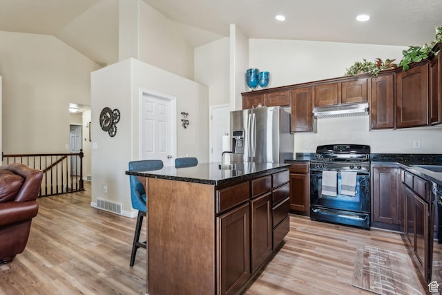 1044 S 1775 W, Syracuse, UT 84075 - kitchen with black gas range, stainless steel fridge, high vaulted ceiling, under cabinet range hood, and a kitchen bar