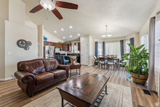 1044 S 1775 W, Syracuse, UT 84075 - living room with lofted ceiling, light wood-type flooring, a chandelier, baseboards, and a ceiling fan