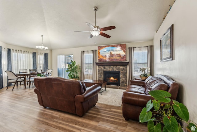 1044 S 1775 W, Syracuse, UT 84075 - living room featuring wood finished floors, a ceiling fan, a stone fireplace, a chandelier, and a textured ceiling