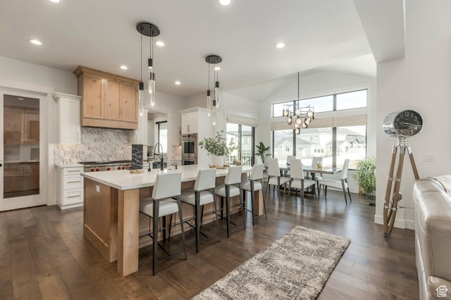 717 N Bridal Creek Ln E, Heber City, UT 84032 - kitchen with light countertops, a kitchen breakfast bar, backsplash, dark wood-style floors, and lofted ceiling