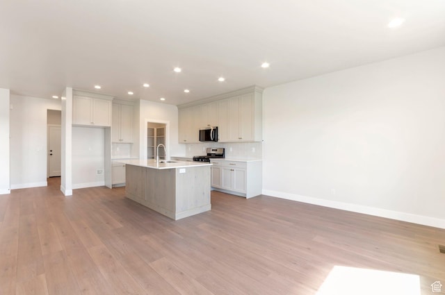 2133 N 725 W, Centerville, UT 84014 - kitchen with appliances with stainless steel finishes, light wood-style flooring, baseboards, an island with sink, and a sink