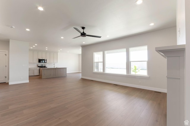 2133 N 725 W, Centerville, UT 84014 - unfurnished living room featuring ceiling fan, recessed lighting, baseboards, light wood-type flooring, and a sink