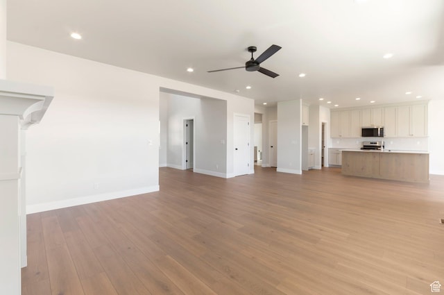 2133 N 725 W, Centerville, UT 84014 - unfurnished living room with ceiling fan, recessed lighting, light wood finished floors, and baseboards