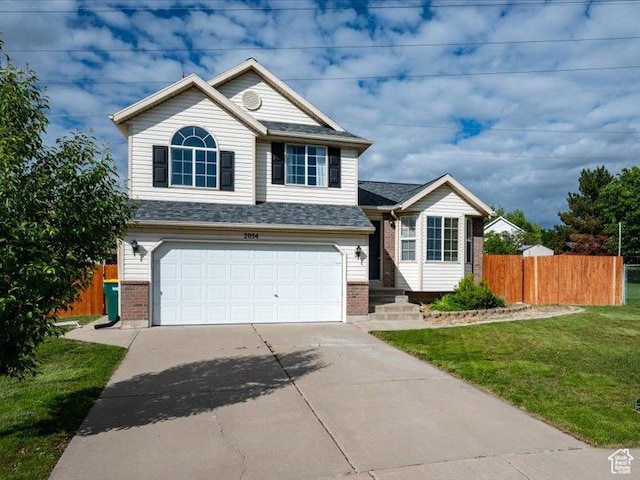 2014 S Jenny Ln, Clearfield, UT 84015 - view of front facade with an attached garage, driveway, and brick siding