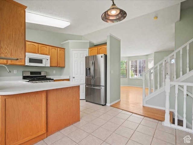 2014 S Jenny Ln, Clearfield, UT 84015 - kitchen with stainless steel appliances, light tile patterned flooring, light countertops, a peninsula, and a sink