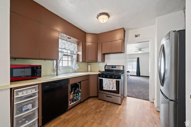 960 Patterson St, Ogden, UT 84403 - kitchen featuring appliances with stainless steel finishes, a sink, light countertops, light wood-style flooring, and a textured ceiling