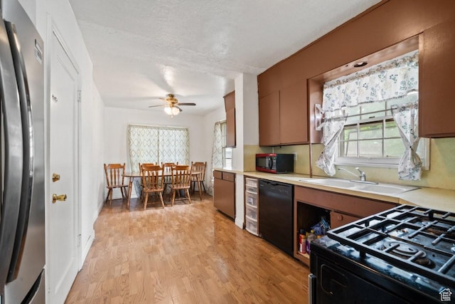 960 Patterson St, Ogden, UT 84403 - kitchen with black appliances, a ceiling fan, light countertops, light wood-style floors, and a textured ceiling